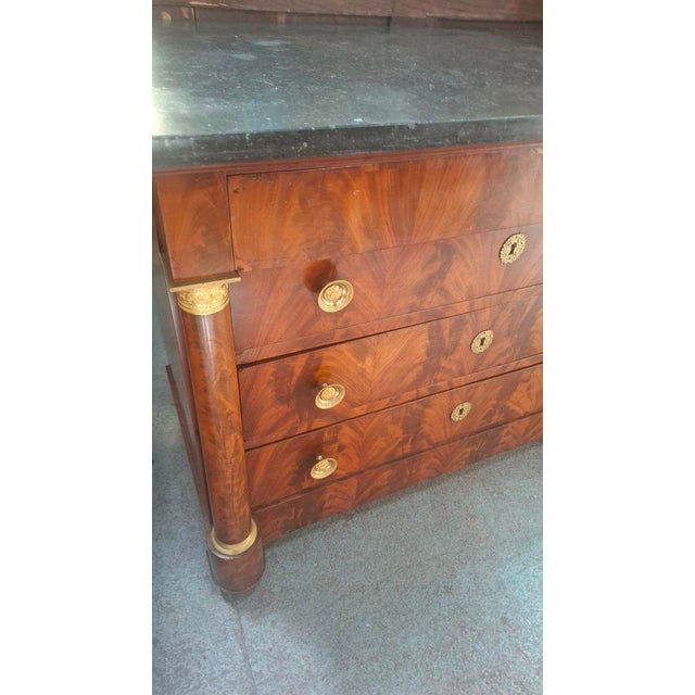Empire period mahogany commode with a marble top. This commode rests on four drawers. It is made of Cuban mahogany. The...