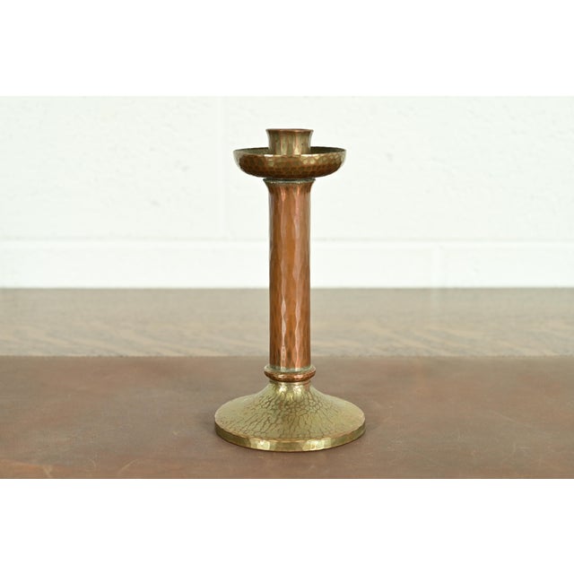 A gorgeous Arts & Crafts period brass finished hand hammered copper candlestick By Roycroft (signed with impressed orb and...