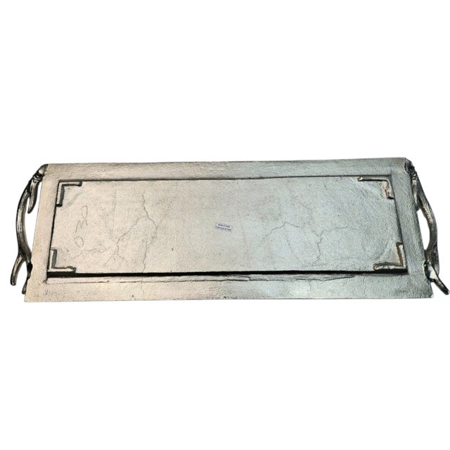 Elegant rectangular silver-tone metal serving platter featuring sculptural antler handles on each end. This substantial...