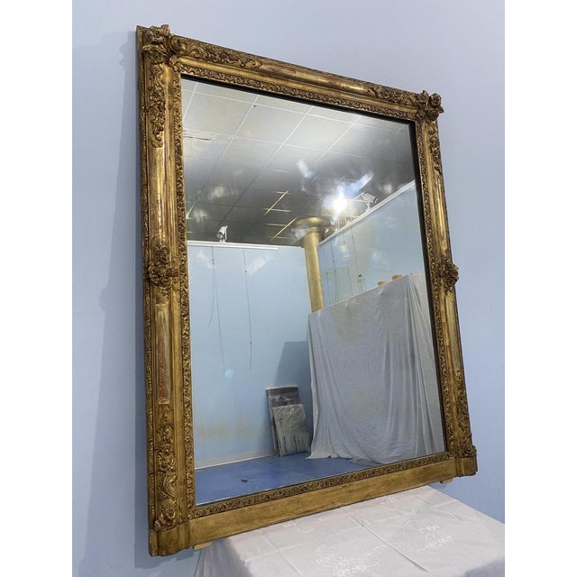 Refined French mirror Napoleon era third, 1870, golden leaf golden. The frame is adorned with splendid floral motifs...