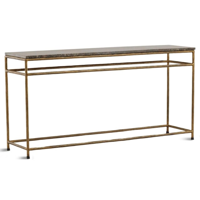 Elegant console table with richly veined Bidasar marble top with a slender iron frame finished in a warm antiqued brass....