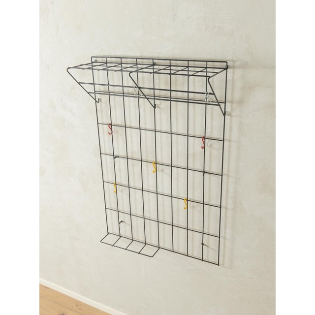 Classic wall-mounted coat rack by Karl Fichtel from the 1960s with colorful coat hooks. High-quality metal frame with a...