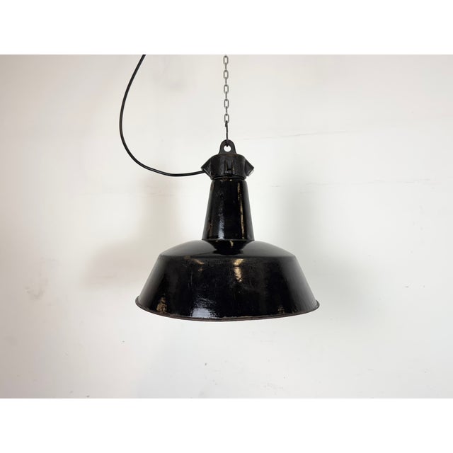 Industrial black enamel pendant light made by Elektrosvit in former Czechoslovakia during the 1950s. White enamel inside...