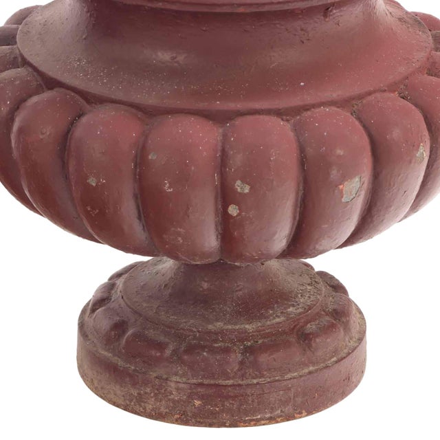 A handsome pair of French garden urns of substantial cast iron construction, each raised on a round molded pedestal and...