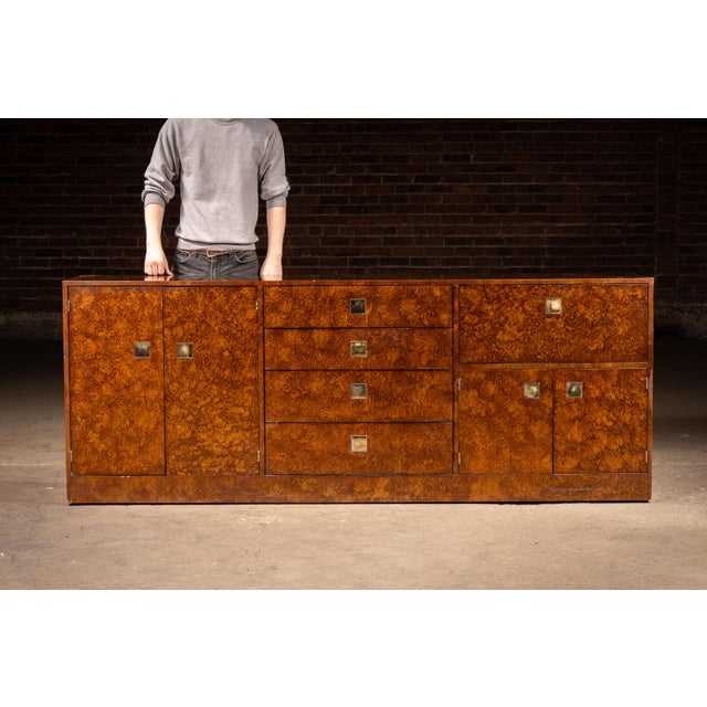 Striking Art Deco credenza executed in richly figured burled walnut veneer, presenting a long, low profile with clean...