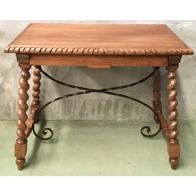 About 19th Spanish farm table with iron stretchers, hand carved top and drawer. An unusual form with nice shiny patina....