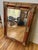 Grand 19th century Gilded Age Style Wall Mirror featuring an ornate & detailed frame with gold gilded moldings & inset red...