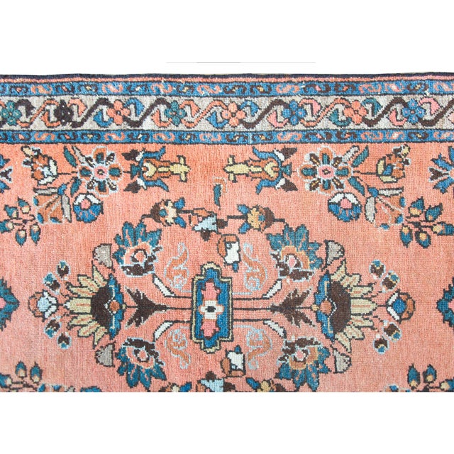 An early 20th century Persian Lilihan rug with a wonderfully rendered mirrored floral pattern woven in indigo, gold,...