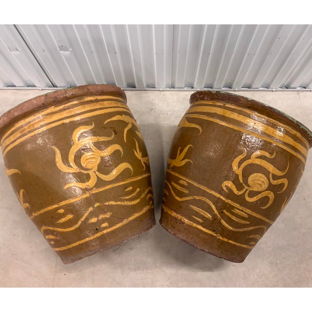 A striking pair of vintage Chinese export jardinieres featuring sculptural dragon relief decoration and rich earth-toned...