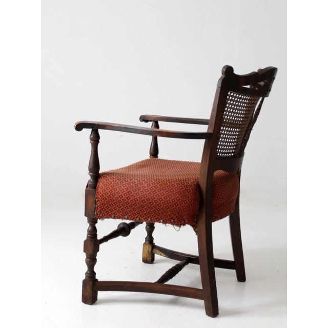 This is an antique Louis XII style armchair. The wooden accent chair features a caned back with upholstered seat, claw...