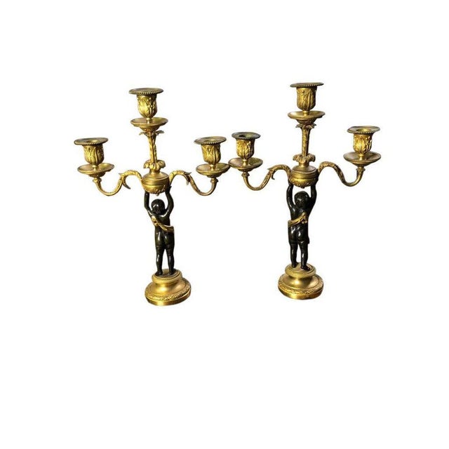 This fine antique pair of french louis xv style gilt and patinated bronze candelabra date from the 19th century. Detailed...