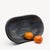 A footed ceramic bowl designed by Fridegart Glatzle for Karlsruher Majolika in West Germany. Its low oval body and softly...