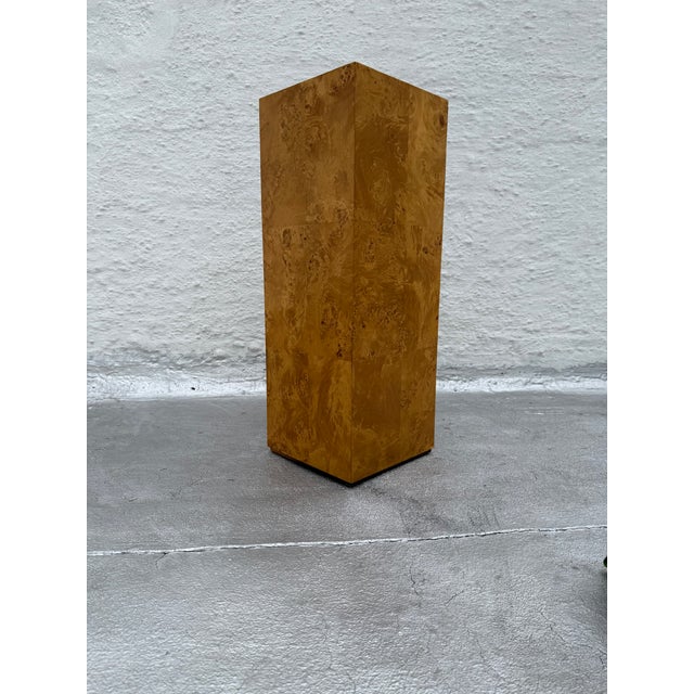 Burl veneer over wood pedestal on a black painted plinth base. There are no manufacturer’s marks on the pedestal.