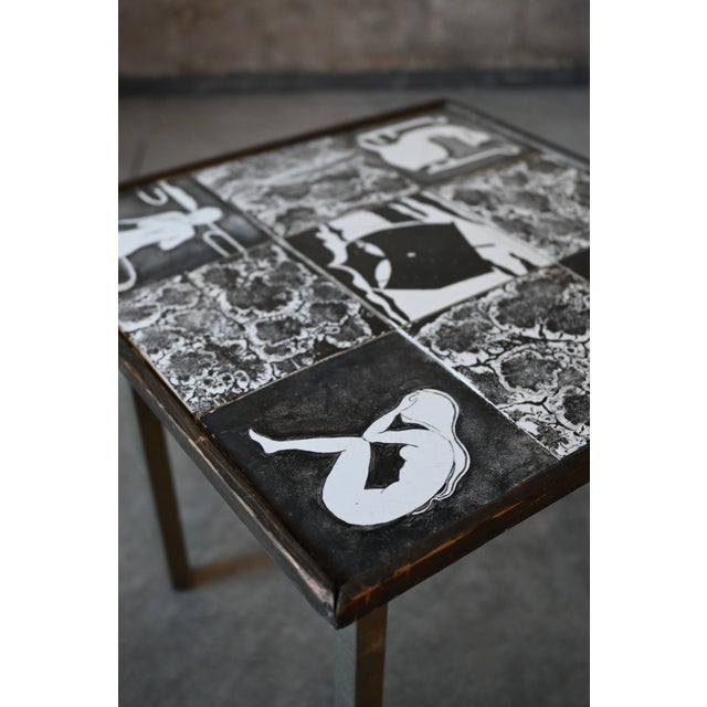 Live with art! A Danish monochromatic tile top side table. Five tiles are figural showing women and a boat at the center,...