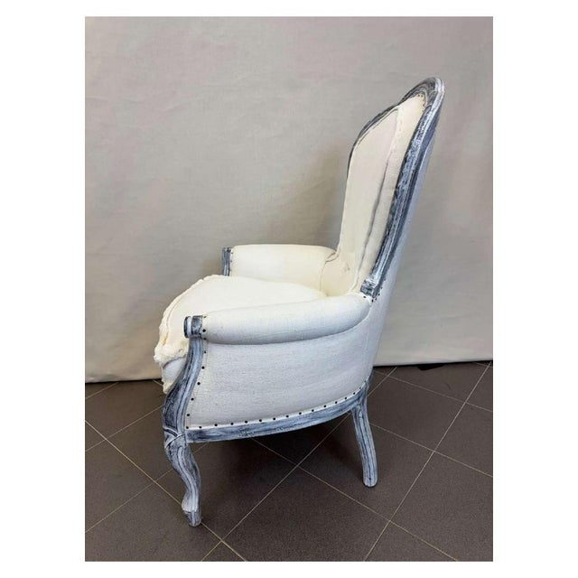 Armchair covered with old white cotton loom-woven sheets, finished with visible upholsterer's nails