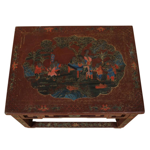 A Chinese red lacquered table with intricate gilt decoration depicturing flora, figures and geometric design and fretwork...