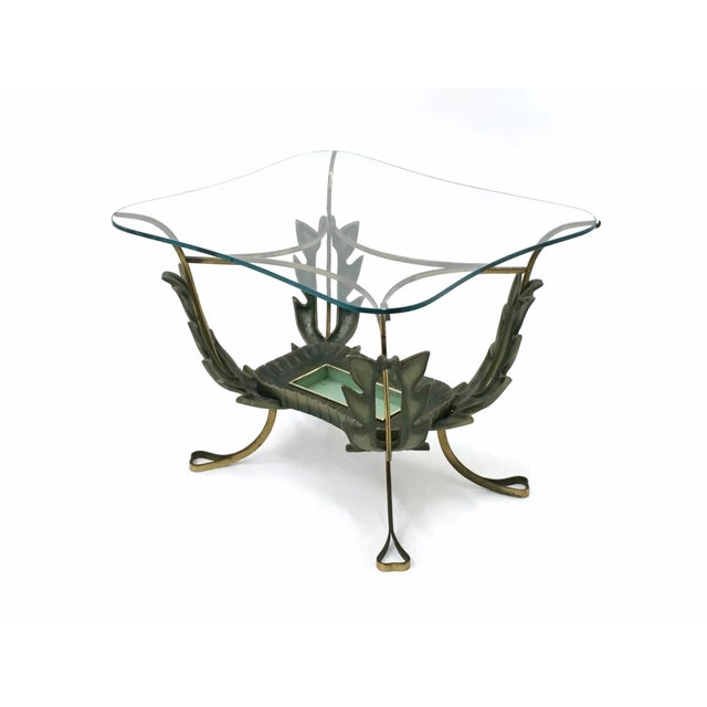 Made in Italy, 1950s. This coffee table features a brass and varnished metal frame and a glass top. It is a vintage item,...