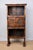 A solid wood bookcase with carved doors and aprons, mid-20th century, Spanish. Features iron T hinges with matching latch...