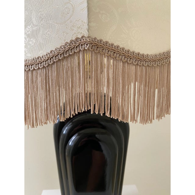 A lovely art deco black ceramic lamp with gorgeous silk shade with fringe trim. Shade features a tone on tone floral pattern.
