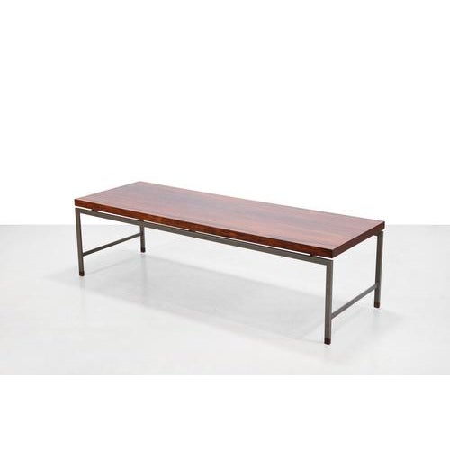 A typically Dutch modernist coffee table from the 1960s, featuring a sleek gray metal frame with warm rosewood as a...