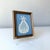 Vintage framed miniature framed crochet pineapple on carolina blue matting.