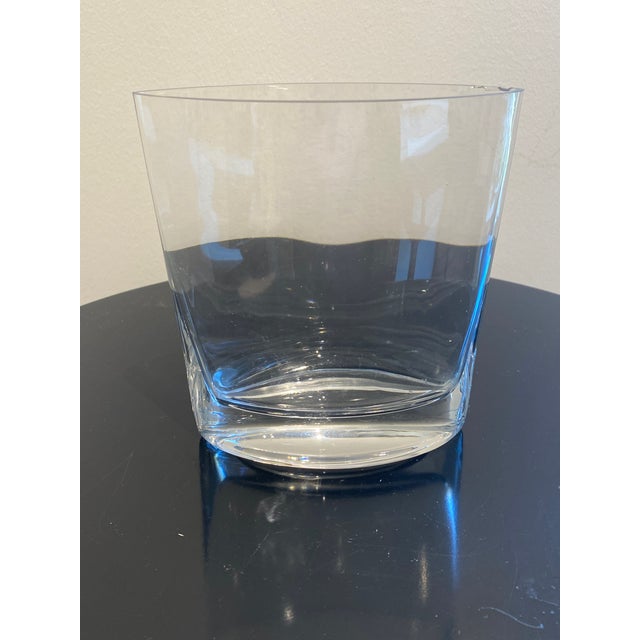 This elegant clear glass vase features a contemporary design with a heavy, weighted base and subtly curved sides that...