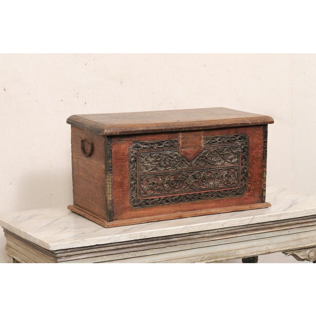 An Indonesian carved teak wood storage box from the early 20th century. This antique wood carved table top chest has a...