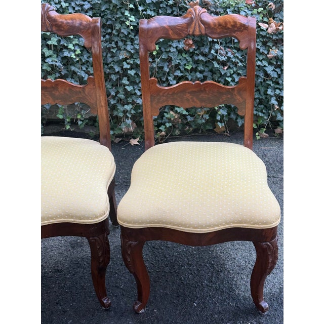 Elegant pair of 19th-century Victorian chairs crafted in richly figured flame mahogany, showcasing beautiful grain...
