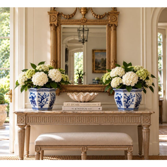 A classic pairing of blue and white porcelain planters, rendered in a softly faceted, scalloped form that feels both...
