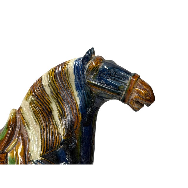 This magnificent glazed ceramic horse sculpture is rendered in the vibrant sancai (three-color) style, featuring a rich,...