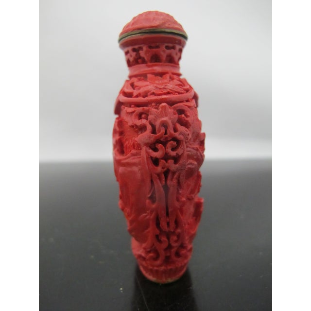 Vintage Chinese snuff bottle. Carved cinnabar lacquerware over brass showing intricate village or pagoda scene. Carved...