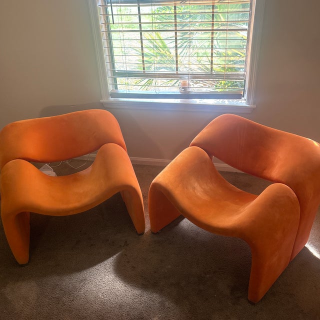 My stroking matching pair of vintage sculptural lounge chairs feature a bold orange form and distinctive chrome support.