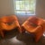 My stroking matching pair of vintage sculptural lounge chairs feature a bold orange form and distinctive chrome support.