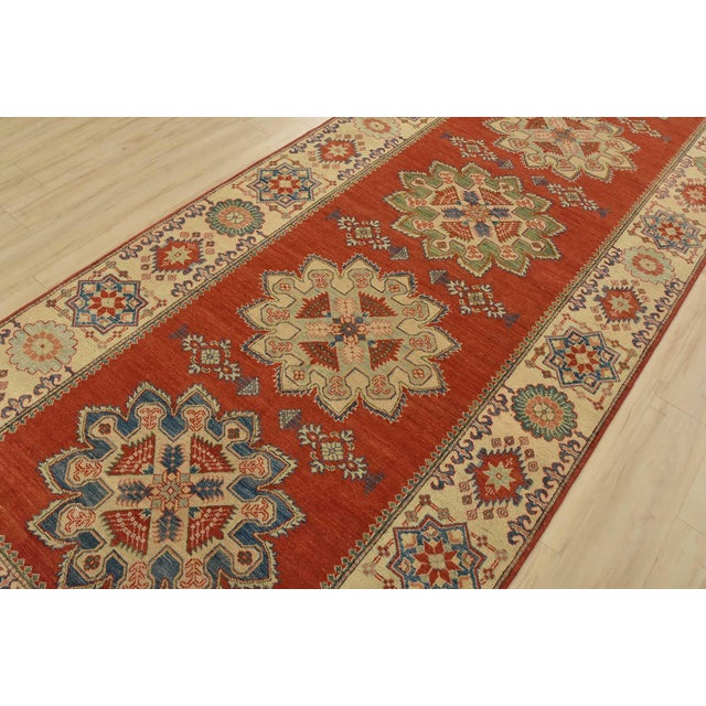 A tribal Caucasian Kazak rug hand-knotted with fine wool on a cotton foundation. This rug features a row of medallions set...