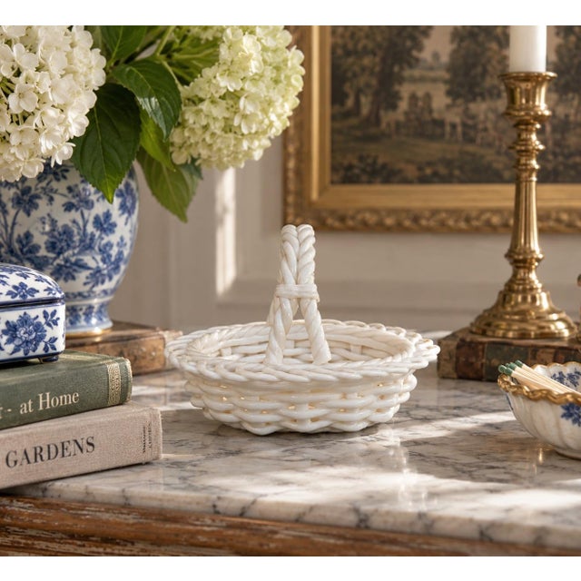 A charming circa 1980s white ceramic basket modeled in remarkably convincing trompe-l’oeil basketry. The open reticulated...