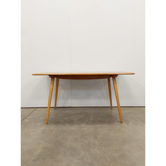 Authentic vintage plank dining table. Model 382 by Ercol. Solid elm wood top and beech wood legs. Maker's label on bottom....