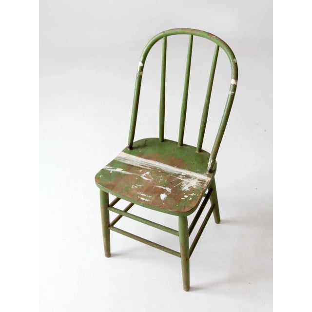 This is an antique painted bow-back Windsor chair. The charming farmhouse dining chair features a classic spindle back and...