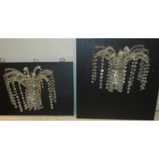 Pair of beaded waterfall-type sconces. They have 1 up and 1 down chandelier socket on a metal base plate. Beads are...