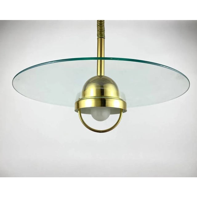 Large vintage ceiling lamp in modern style. Germany, 1980s. glass disk light featuring the brass light source housing with...