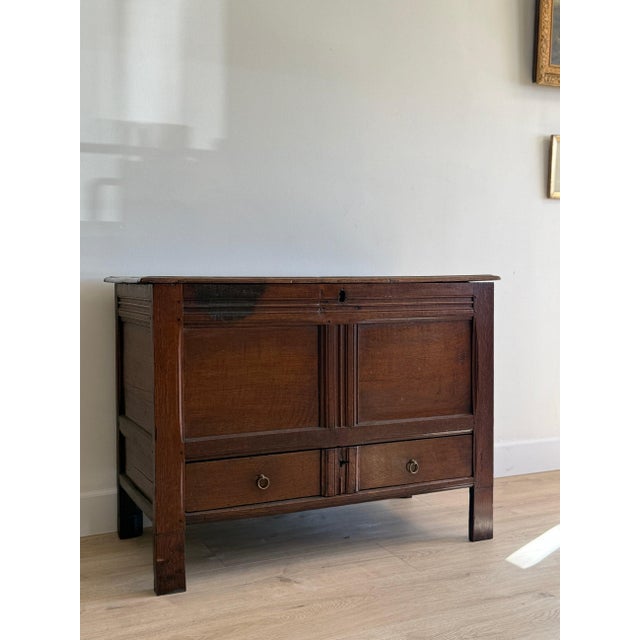A handsome late 18th century English oak coffer, crafted with a restrained paneled front and fitted with an unusual lower...