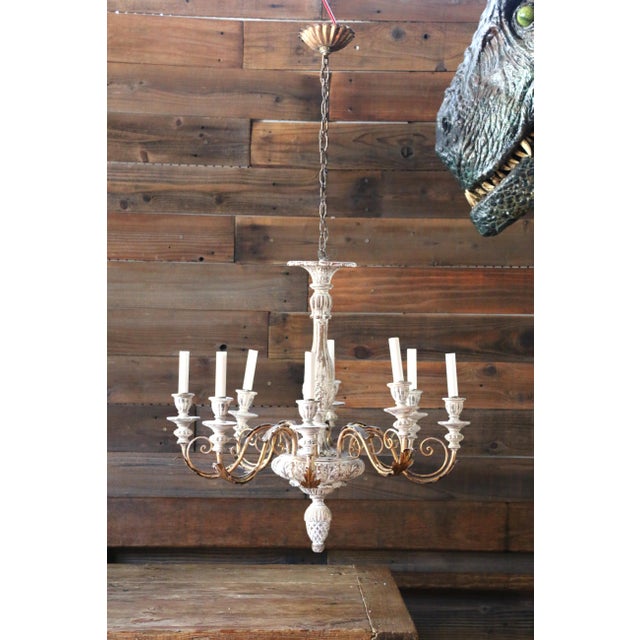 A striking monumental Italian eight-light chandelier dating to the 1940s, beautifully combining carved and painted wood...