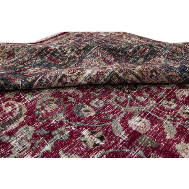 Beautiful hand-knotted antique Mashad wool rug. This rug has a red field with green and tan accents. This rug features a...