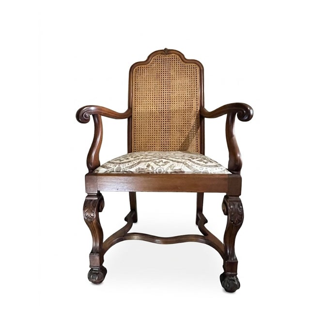 A handsome pair of Louis XV style walnut fauteuils with pressed-cane backs, scrolling arms, and carved cabriole legs...