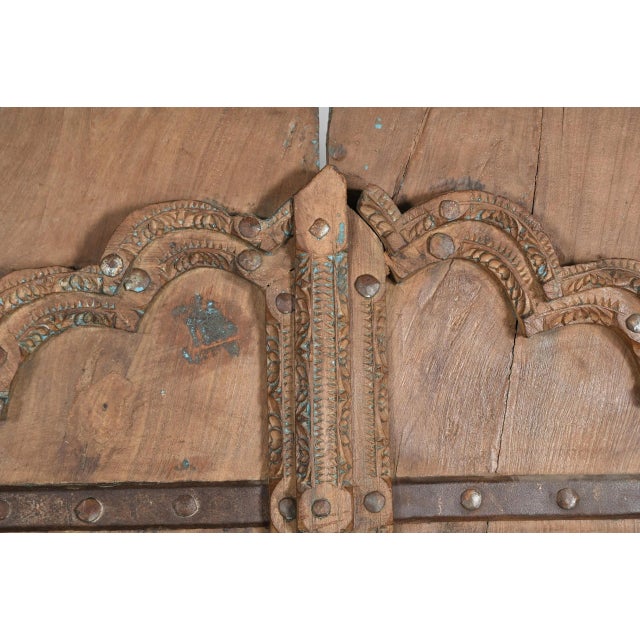 Antique Indian Carved Teakwood and Iron Door, the top with a shaped arch, with a carved outline and center style. A very...