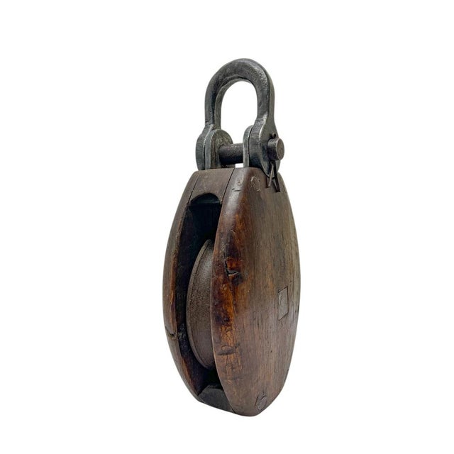 Robust antique 19th-century solid wood pulley with wrought iron bracket and pin and a wooden wheel. Such pulleys were used...