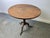 A 19th century Georgian-style oak tilt-top occasional table. The circular top, displaying a rich figured grain and...