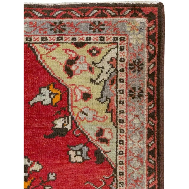 A wool pile of symmetric knots on a cotton foundation. An elongated cartouche medallion, featuring a central pair of...