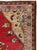 A wool pile of symmetric knots on a cotton foundation. An elongated cartouche medallion, featuring a central pair of...