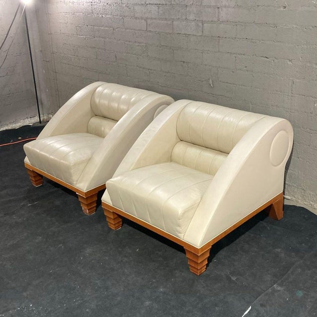 This set includes two Giorgetti lounge chairs with a modern design. Both chairs feature cream-colored leather upholstery...