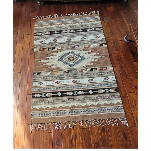 Infuse your space with warmth and heritage using this striking, Zapotec Southwestern style 100 % wool woven rug. Featuring...